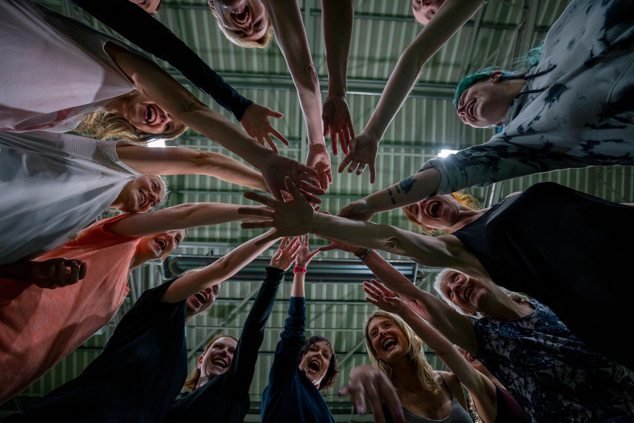 Community members with hands together in a circle, symbolizing support and prayer