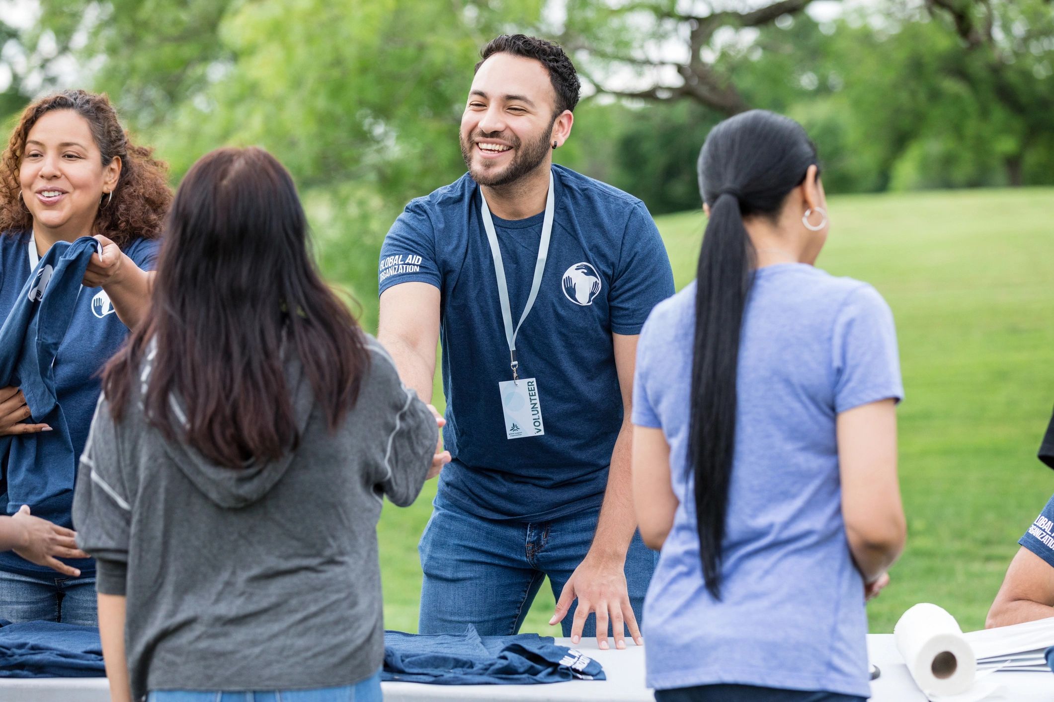 Volunteer greeting someone with a handshake, representing outreach and care