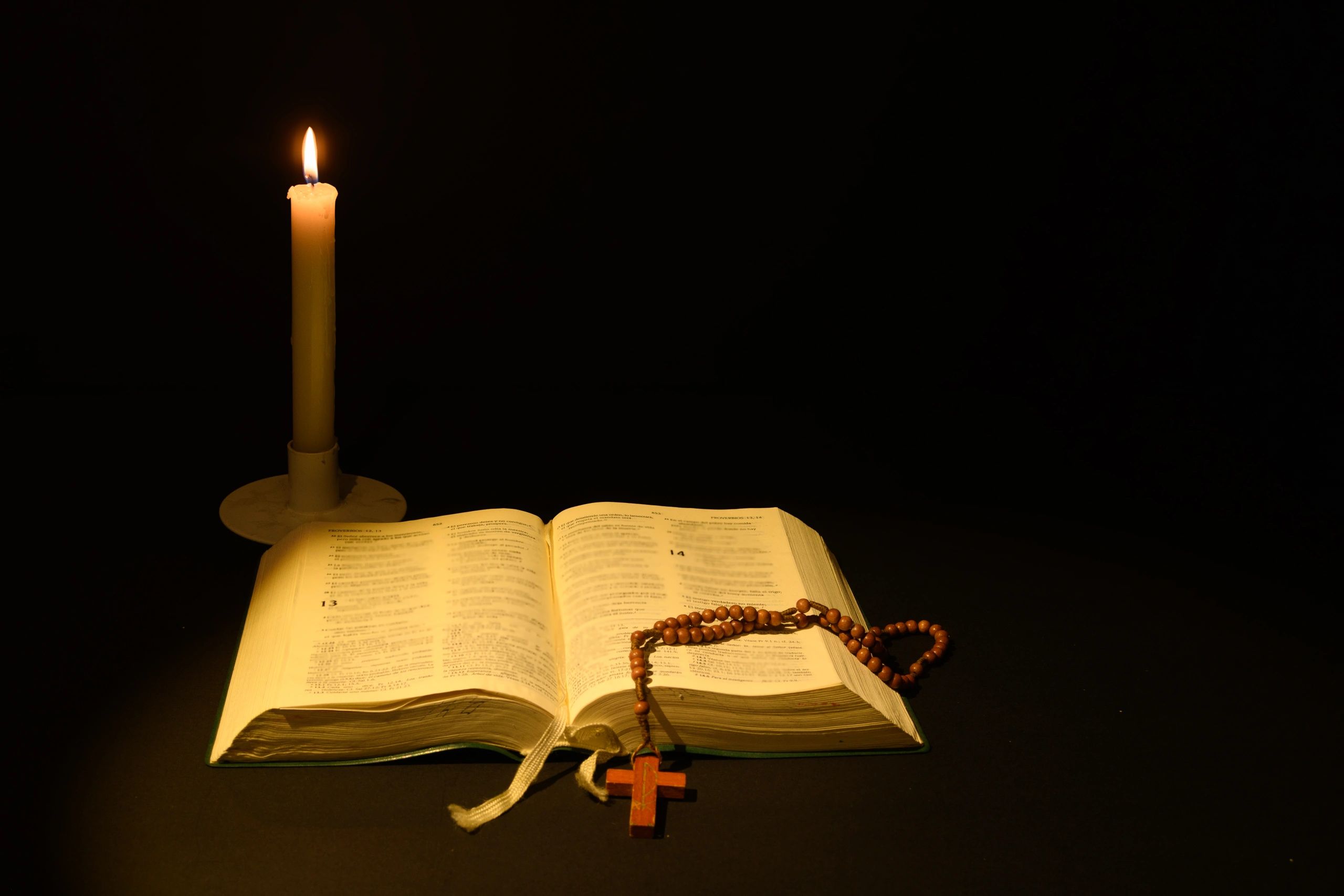 Open Bible with a lit candle, representing prayer and reflection